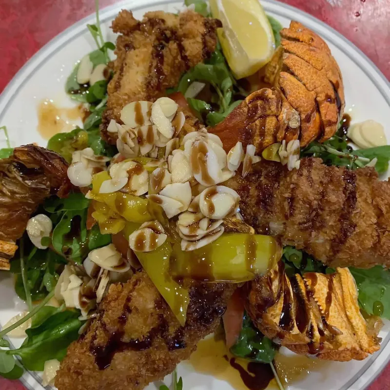 Fried appetizer platter over arugula with pickled peppers and lemon