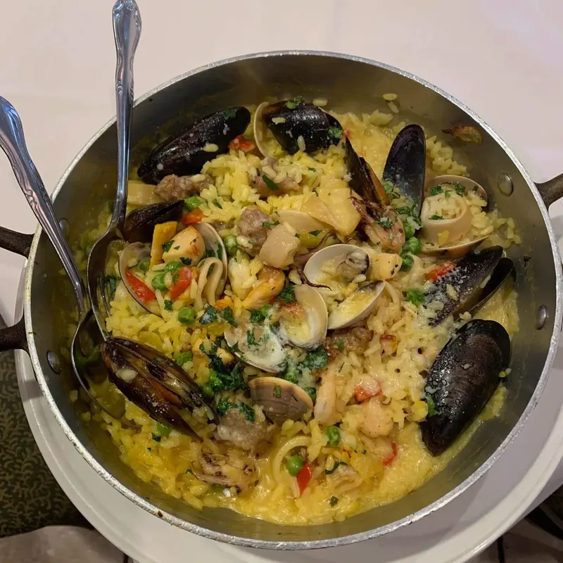 Pan of mussels and clams over saffron rice