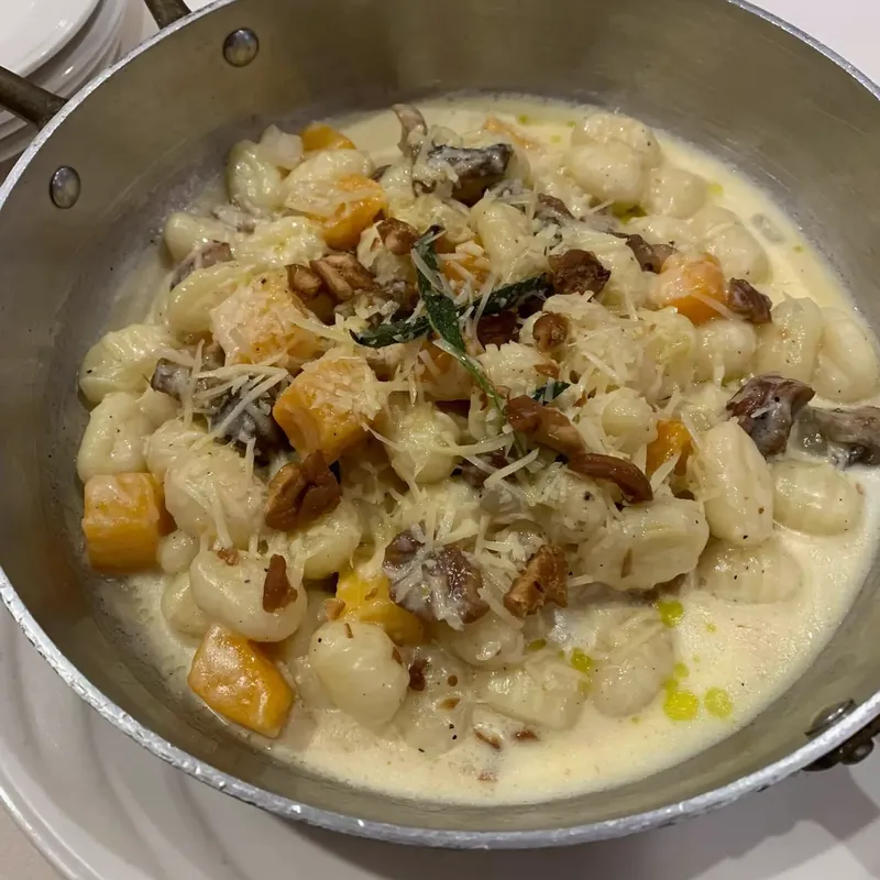 Gnocchi in cream sauce with squash and mushrooms, served in the pan