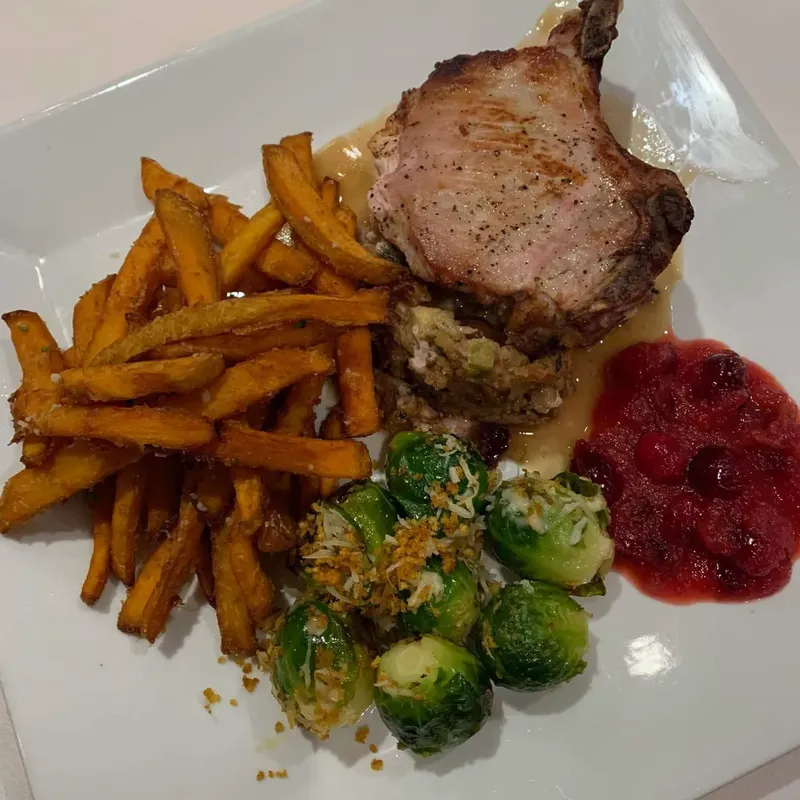 Pork chop with sweet potato fries, Brussels sprouts and berry sauce